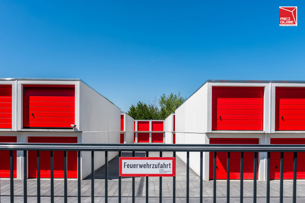 Selfstorage-Park Haupttor-Einfahrt mit Blick auf zweireihige Garagen und Schild mit dem Hinweis auf eine Feuerwehreinfahrt
